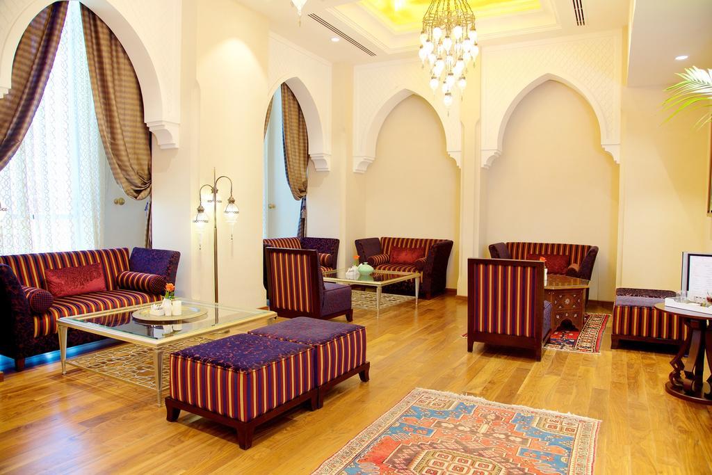 Pullman Resort Al Marjan Island Ras al-Khaimah Exterior photo The photo shows a beautifully designed interior space, featuring a seating area with plush chairs and couches arranged around a low table. The furniture is characterized by vibrant striped upholstery in shades of purple and red. The walls are elegant